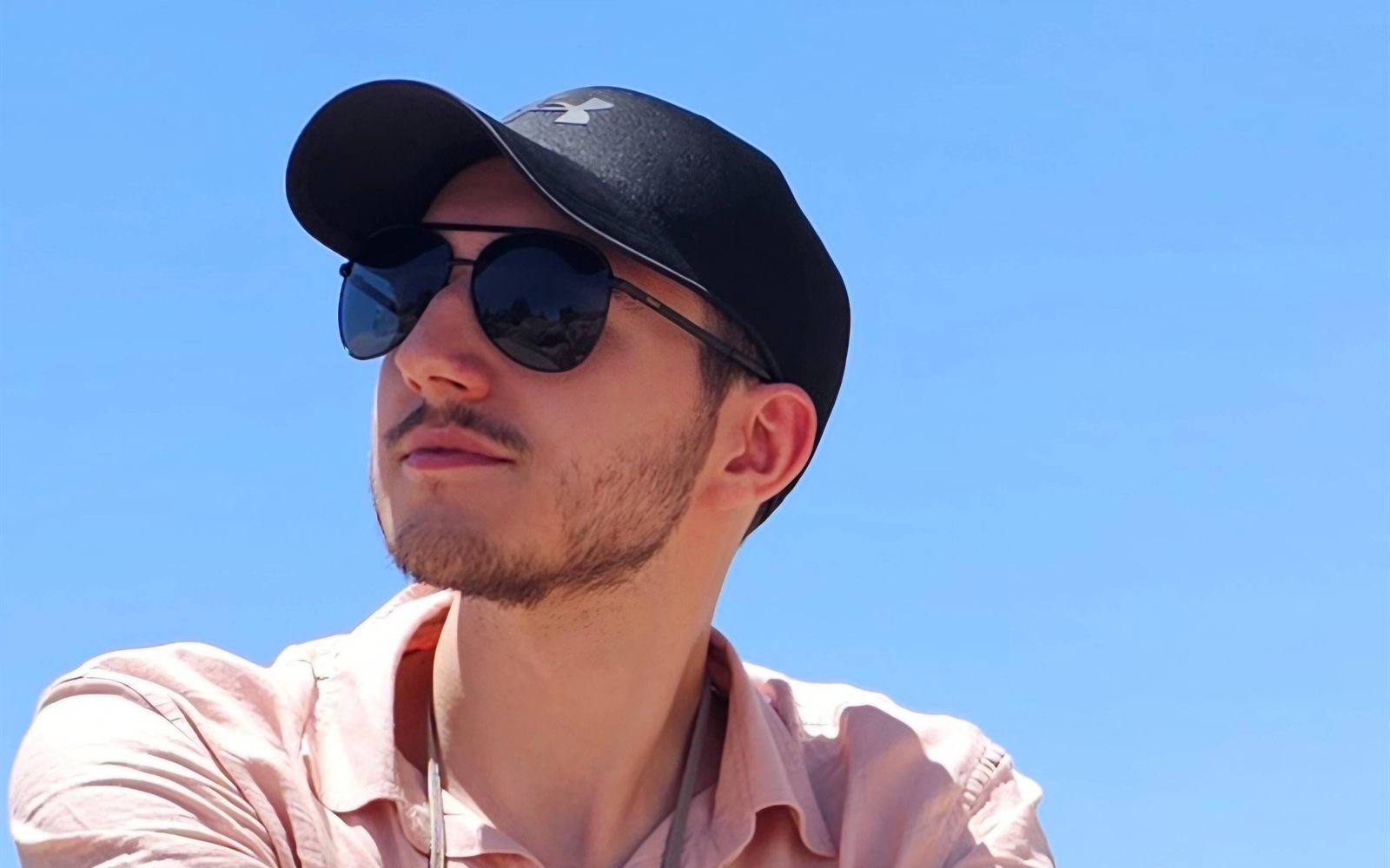 Bogdan Gerasymenko in a cap and sunglasses against a clear blue sky